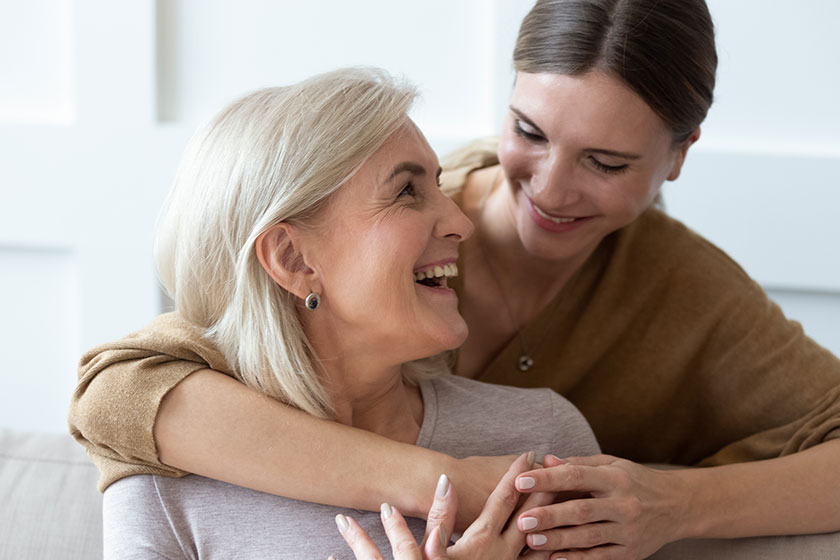 Grownup daughter hugging senior mom showing love and care