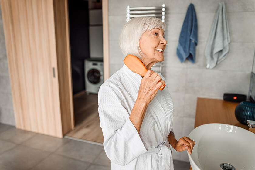 cheerful-old-woman-brushing-hair