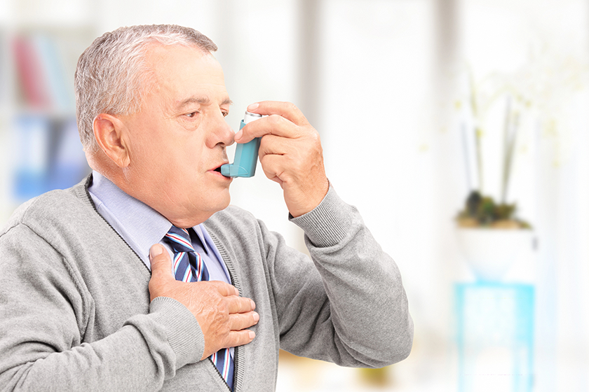 Man treating asthma with inhaler